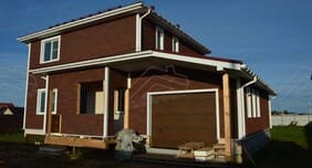 Фасад двухэтажного СИП-дома Соколь с гаражом и верандой