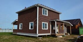 Дом с левой стороны, видны окна и фасад