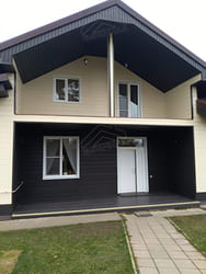 Окно на фасаде с тёмным вертикальным сайдингом